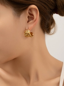 Détail de boucles d'oreilles C plaquées or 18 carats avec texture lave sur mannequin