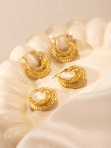 Vue détaillée de boucles d'oreilles en C plaquées or 18k sur plateau en soie