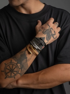 Close-up of twisted titanium steel cable bracelets in gold, silver, and black finishes