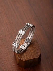 Detailed close-up of a triple-strand stainless steel cable bracelet with polished clasps
