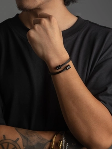 Male model wearing a black stainless steel twisted cable cuff bracelet in industrial style