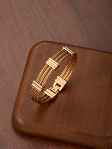 Macro shot of 18k gold plated stainless steel triple cable bracelet with industrial accents