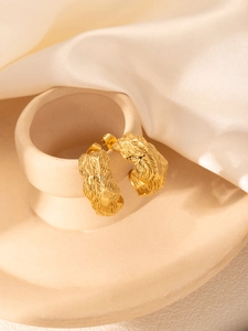 Gros plan sur les boucles d'oreilles en C plaquées or 18 carats avec texture plume