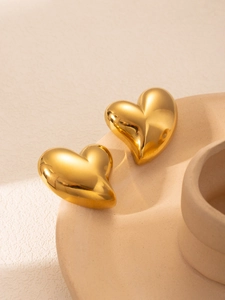 Vue détaillée des boucles d'oreilles cœur dorées 3D avec une finition miroir polie