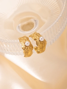 Détail de boucles d'oreilles C plaquées or 18k avec texture lave et perles blanches