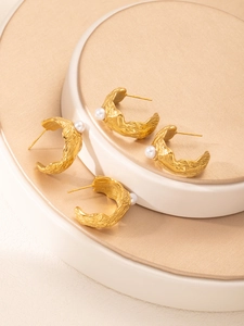 Détail macro des boucles d'oreilles goutte en or 18k avec texture lave et perles