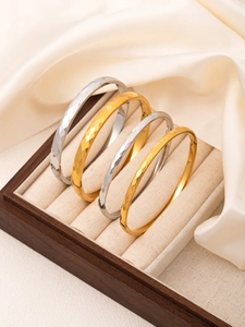 Macro detail of geometric hammered gold and silver titanium steel bangles in jewelry box