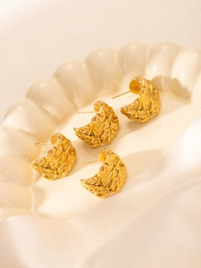 Vue macro de quatre boucles d'oreilles en C plaquées or 18 carats avec texture martelée