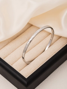 Detailed view of silver titanium steel bangle with hammered texture in a velvet box