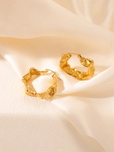 Détail des boucles d'oreilles C plaquées or 18 carats avec texture irrégulière martelée
