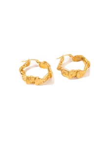 Détail macro de boucles d'oreilles C plaquées or 18 carats avec texture martelée