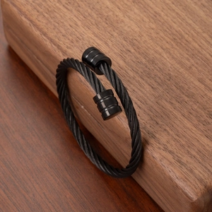 Twisted black steel cable cuff bracelet for men with 18k gold plated cylinder ends