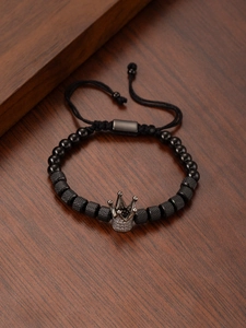 Macro detail of men's beaded crown bracelet with cubic zirconia and woven cord