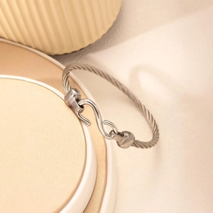 Detailed close-up of a silver stainless steel cable rope bracelet with S-hook clasp