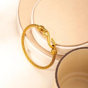Detailed macro view of 18k gold plated cable wire bracelet with a unique S-hook clasp