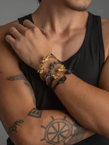 Detailed close-up of three dragon head wire bracelets in gold, silver, and black finishes
