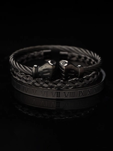 Close-up of men's triple black steel bracelet set with boxing glove and Roman details
