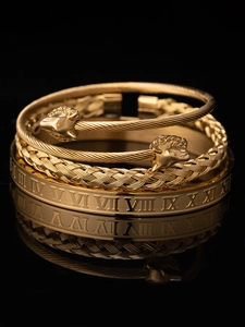 Dettaglio del set di bracciali in acciaio al titanio dorato con numeri romani e treccia