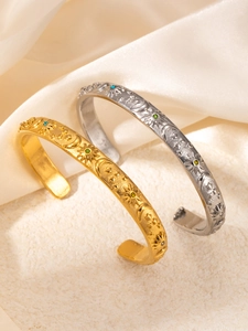 Detalle de brazaletes de sol y luna grabados en oro y plata con gemas incrustadas