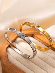 Gros plan de bracelets en acier inoxydable doré et argenté avec pavé de cristaux en X
