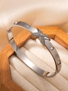Détail du bracelet en acier argenté avec motif en X et cristaux scintillants