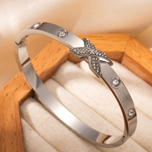 Bracelet jonc en acier argenté avec motif X serti de diamants dans un écrin en bois