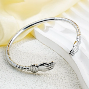 Minimalist silver hug hand cuff bracelet with sunburst texture on a premium display stand