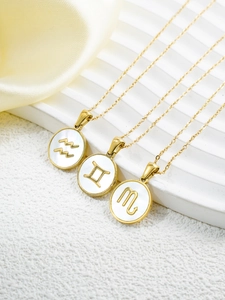 Close-up of 18k gold plated constellation necklaces with white shell inlay pendants