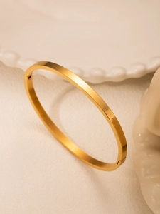 Detail of 18k gold plated stainless steel bracelet with a smooth matte finish and hinge
