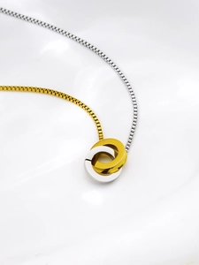 Close-up of interlocking gold and silver circles on a polished Venetian chain necklace