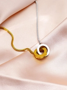 Macro shot of interlocked gold and silver rings on a dual-tone box chain necklace
