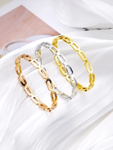 Detailed view of three-color minimalist hollow geometric bracelets on white silk