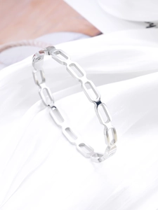 Detailed macro view of silver hollow chain link bangle in a minimalist geometric design