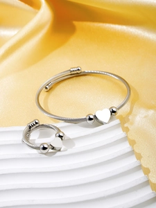 Macro shot of silver heart cuff bracelet and ring set with twisted rope texture
