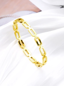 Detailed close-up of 18k gold plated hollow rectangle link bracelet on white silk fabric
