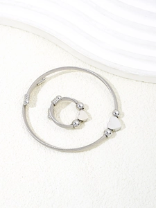 Detailed view of silver twisted cable bracelet and ring set with heart charms