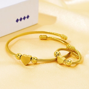 18k gold plated cable bracelet and heart ring set on elegant silk background