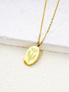 Gros plan du collier avec pendentif fleur ovale doré sur fond de pierre blanche