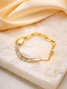Detail of gold padlock bracelet with rectangular zircons and flat links on silk