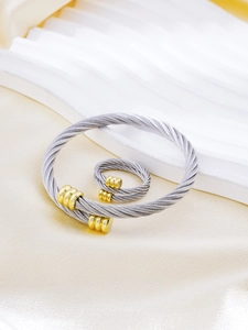 Macro detail of twisted steel cable jewelry set with two-tone gold and silver finish