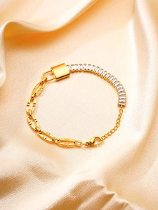 Detail of gold bracelet featuring rectangle cubic zirconia and silk champagne background