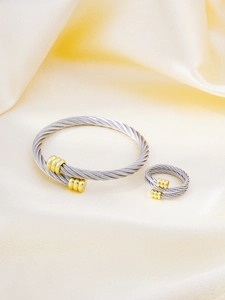 Detail of twisted cable bangle and matching ring set with two-tone metal finish