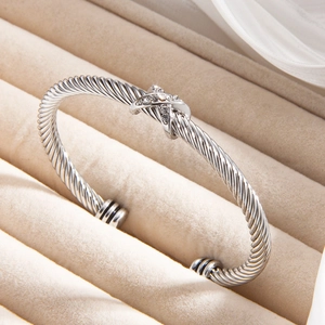 Silver twisted cable cuff bracelet with X-shaped diamond-set knot detail and open end