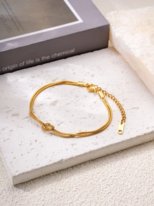 Détail du bracelet chaîne serpent dorée avec nœud central et poinçon de qualité acier