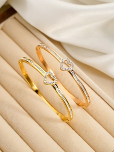 Détail de bracelets cœur ouverts sertis de micro-diamants en or et or rose