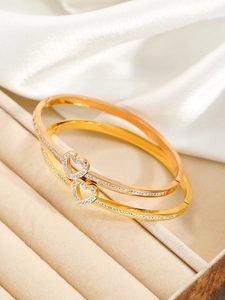Détail de bracelets en acier inoxydable en forme de cœur avec serti de zircons