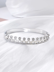 Detailed close-up of crown-shaped silver titanium steel bracelet with sparkling zircons