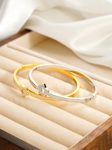 Détail de bracelets étoiles or et argent avec cristaux sur soie dans un écrin à bijoux