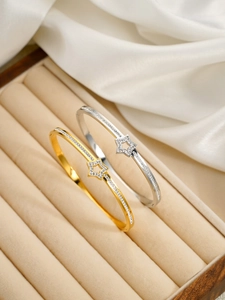 Détail de bracelets étoiles évidées dorés et argentés sertis de zircons sur soie