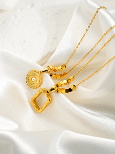 Détail du pendentif soleil doré avec perle et pendentif carré sur soie et pierre